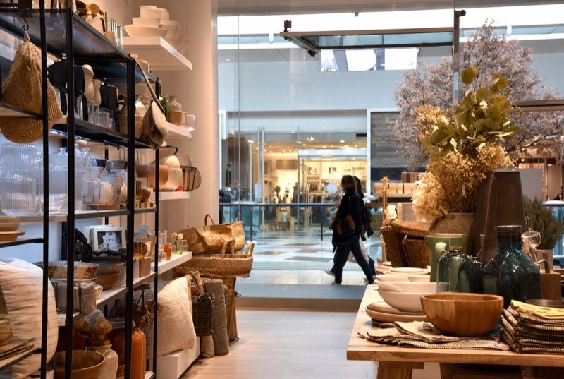 A well-lit store aisle stocked with gifts and household items